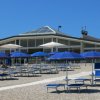 Spiaggia con ombrelloni blu e un edificio.