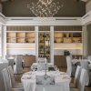 Una sala da pranzo elegante con tavoli apparecchiati e un grande lampadario.
