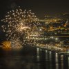 Fuochi d'artificio sopra una città costiera di notte.