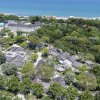 Vista aerea di case tra alberi vicino alla spiaggia.