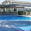 Piscina azzurra con casa sullo sfondo.