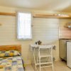 Interno con letto singolo, tavolo e angolo cottura.