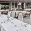 Ristorante all'aperto con tavoli apparecchiati eleganti.