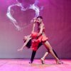 Una coppia balla appassionatamente con sfondo a cuore luminoso.