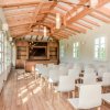 Una sala conferenze luminosa con sedie bianche e soffitto in legno.