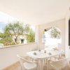Terrazza con tavolo bianco e sedie.