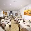 Sala da pranzo con tavoli apparecchiati.