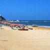 Spiaggia con lettini e ombrelloni rossi vicino al mare.