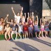 Gruppo di bambini su un palco che salutano.