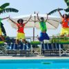 Quattro persone saltano vicino a una piscina.