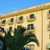 Facciata di un hotel con balconi e palme.