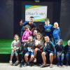 Un gruppo di persone sorride su un palco d'erba.