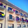 Facciata di un edificio con balconi pieni di panni stesi.