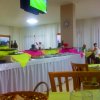 Sala da pranzo con buffet colorato e televisore a parete.