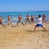 Persone fanno esercizi sulla spiaggia.
