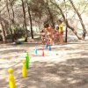 Bambini giocano a bowling all'aperto tra gli alberi.