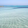 Mare trasparente con orizzonte azzurro.