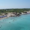 Spiaggia affollata con mare turchese.